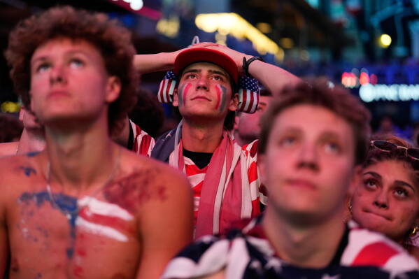 Fans react to a United States loss during a watch party for a World Cup round of 16 soccer match between the United States and Belgium at the KC Live! entertainment district Monday, July 6, 2026, in Kansas City, Mo. (AP Photo/Charlie Riedel)