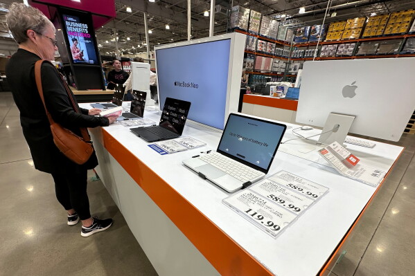 A shopper looks over Apple MacBook laptops on display in a Costco warehouse on June 2, 2026, in Sheridan, Colo. (AP Photo/David Zalubowski, File)