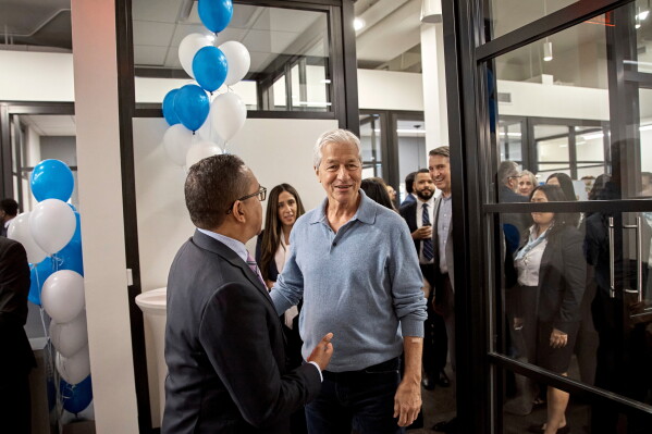 Jamie Dimon, CEO and chairman of JPMorgan Chase, center right, talks with an attendee during the community branch opening in the Bronx borough of New York, April 26, 2024. (AP Photo/Andres Kudacki, File)