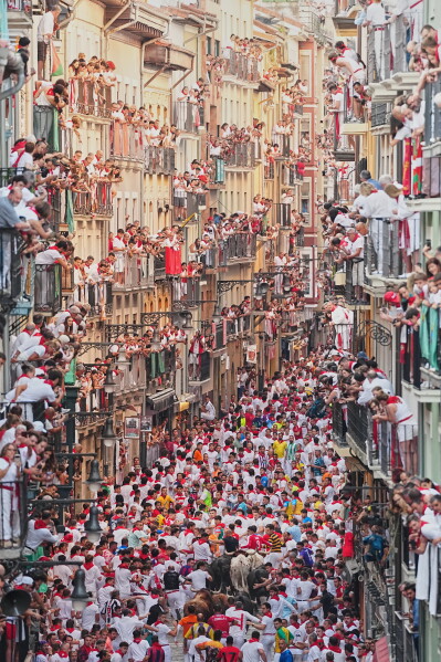 Revelers run alongside Victoriano del Río's fighting bulls during the third running of the bulls at the San Fermín festival in Pamplona, Spain, Thursday, July 9, 2026. (AP Photo/Miguel Oses)