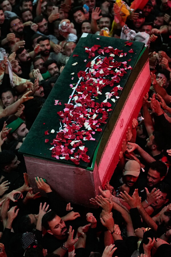 The coffin of the late Iranian Supreme Leader Ayatollah Ali Khamenei, covered with flower petals, is carried by mourners outside the Imam Hussein Shrine in Karbala, Iraq, early Thursday, July 9, 2026. (AP Photo/Khalil Hamra)