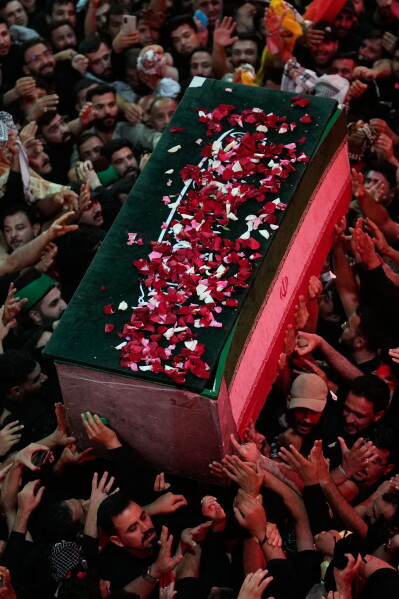 The coffin of the late Iranian Supreme Leader Ayatollah Ali Khamenei, covered with flower petals, is carried by mourners outside the Imam Hussein Shrine in Karbala, Iraq, early Thursday, July 9, 2026. (AP Photo/Khalil Hamra)