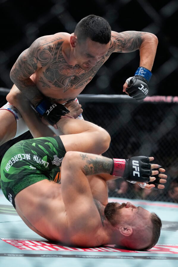 Conor McGregor, bottom, fights Max Holloway in a welterweight fight at the UFC 329 mixed martial arts event Saturday, July 11, 2026, in Las Vegas. (AP Photo/John Locher)
