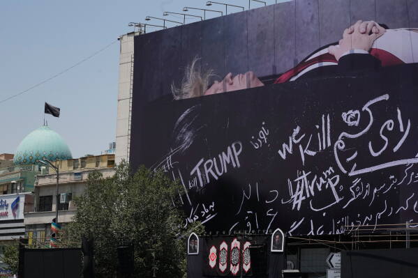 A billboard depicting U.S. President Donald Trump lying on what appears to be a coffin and bearing anti-Trump messages, including the phrase "We Kill Trump," is seen at Islamic Revolution Square in downtown Tehran, Iran, Wednesday, July 15, 2026. (AP Photo/Vahid Salemi)