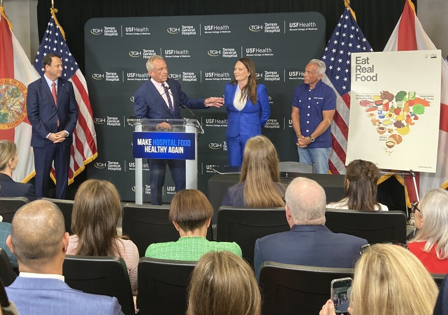 Four people surrounding a podium onstage