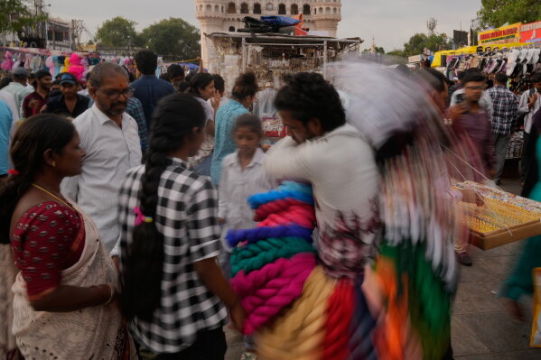 People shop for clothes near the landmark Charminar monument in Hyderabad, India, Saturday, July 11, 2026. (AP Photo/Mahesh Kumar A.)