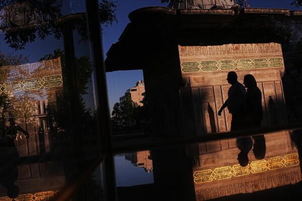 People walk past the Ottoman-era style Tophane public fountain in Istanbul, Turkey, Sunday, July 12, 2026. (AP Photo/Francisco Seco)