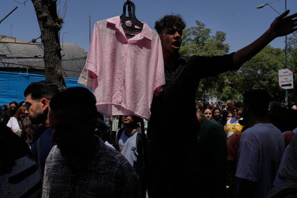 A vendor advertises clothing at Tehran's traditional main bazaar, Iran, Thursday, July 16, 2026. (AP Photo/Vahid Salemi)