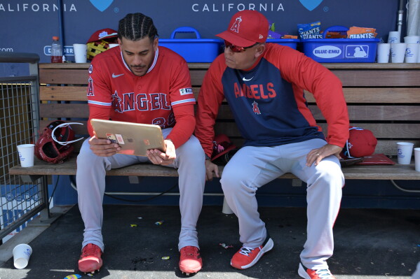 Los Angeles Angels' Jose Siri, left, looks at an iPad in the dugout with Angels' assistant hitting coach Jobel Jiménez during a baseball game against the Los Angeles Dodgers, June 7, 2026, in Los Angeles. (AP Photo/Jayne Kamin-Oncea, File)