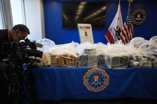 A cameraman records seized evidence at a news conference at the Federal Building in Los Angeles, Tuesday, July 7, 2026. (AP Photo/Jae C. Hong)