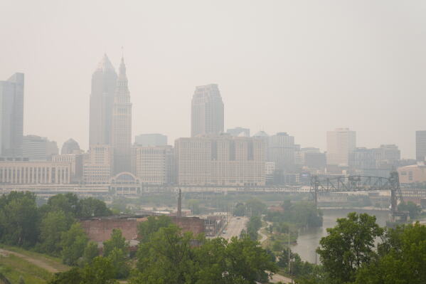 Smoke from Canadian wildfires blankets downtown Cleveland, forcing the postponement of a baseball game between the Pittsburgh Pirates and the Cleveland Guardians in Cleveland, Friday, July 17, 2026. (AP Photo/Sue Ogrocki)