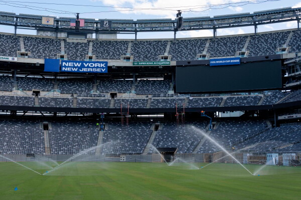 Sprinklers water the grass during the pitch installation for FIFA World Cup 2026 at NYNJ Stadium, Thursday, May 7, 2026, in East Rutherford, N.J. (AP Photo/Yuki Iwamura, File)