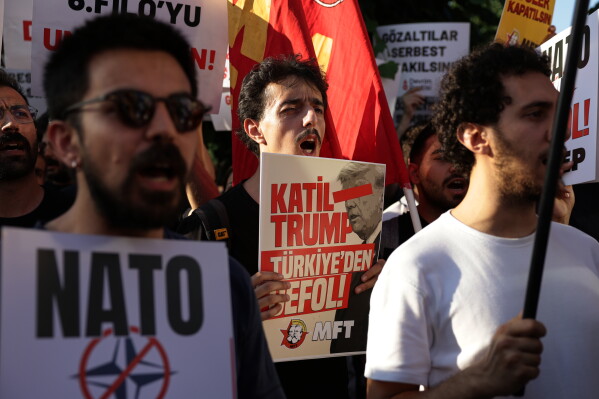 People march during a demonstration against the NATO summit, in Istanbul, Turkey, Tuesday, July 7, 2026. Poster in the center reads in Turkish: "Murderer Trump. Get out of Turkey". (AP Photo/Erdem Sahin)