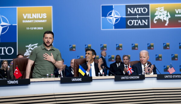 President Volodymyr Zelensky of Ukraine, left, receives applause from NATO members including British Prime Minister Rishi Sunak, center, and U.S. President Joe Biden during a meeting of the NATO-Ukraine Council at the level of Heads of State and Government, with Sweden, at the NATO Summit in Vilnius, Lithuania, Wednesday, July, 12, 2023. (Doug Mills/Pool via AP)