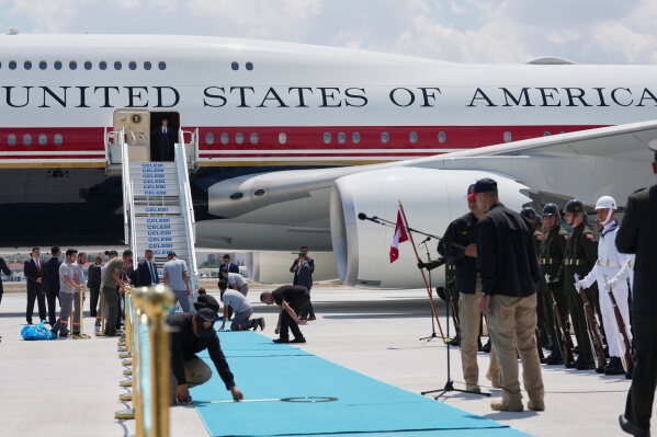 Staff lay a carpet on the tarmac before President Donald Trump exits Air Force One upon arriving for the NATO summit in Ankara, Turkey, Tuesday, July 7, 2026. (AP Photo/Alex Brandon)