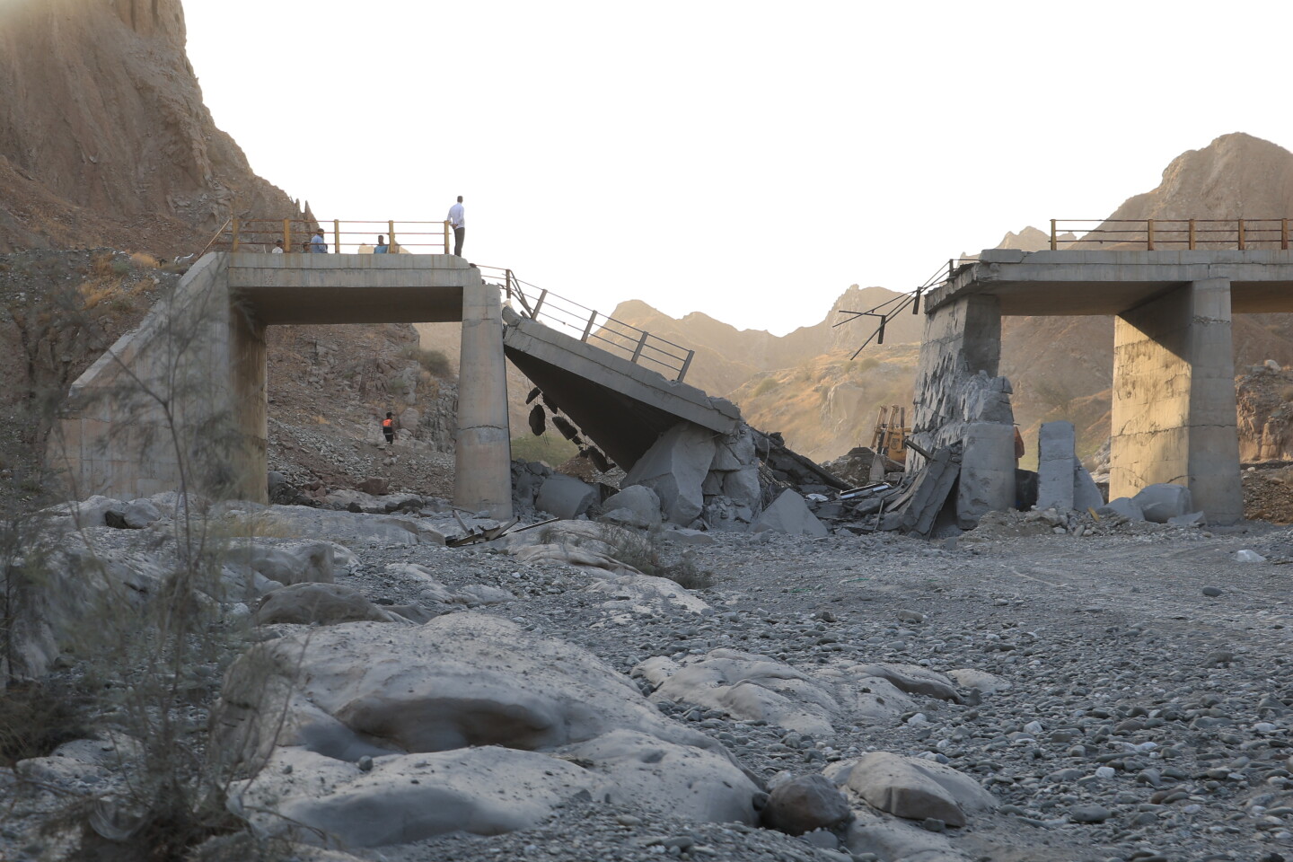 People stand on a bridge destroyed after a strike in Hormozgan province, southern Iran, July 18, 2026. (Amirhosein Khorgooi/Iranian Students' News Agency via AP)