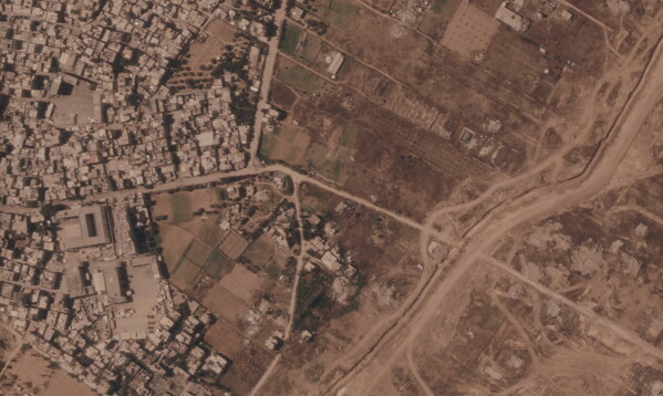 This satellite image from Planet Labs PBC shows a section of an earthen barrier being built by the Israeli military, right side of image moving top to bottom, in the central Gaza Strip, July 1, 2026. At left is the Maghazi refugee camp, and on the other side are homes demolished by the military. (Planet Labs PBC via AP)