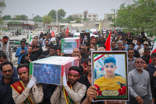 Mourners carry the coffins containing additional remains of victims identified through DNA testing during funeral ceremonies in Minab, Iran, Tuesday, July 22, 2026, nearly five months after they were killed in the Feb. 28 strike on the Shajareh Tayyebeh School.(Razieh Poudat/ISNA via AP)