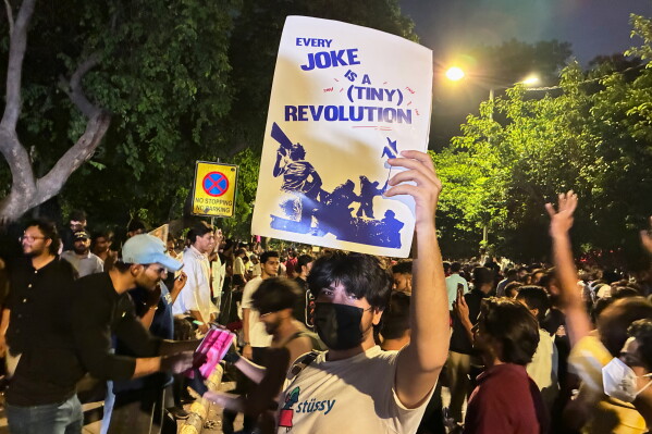 A protestor holds a placard with the message "Every Joke is a Tiny Revolution" during a demonstration demanding educational reforms as part of the Cockroach Janta Party's ongoing protest movement in New Delhi, India, Thursday, July 23, 2026. (AP Photo/Verda Sabzwari)