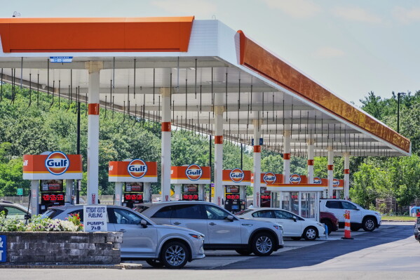 Cars line up at the pumps of a Gulf Oil station on the Massachusetts Turnpike near Boston, Sunday, July 19, 2026. (AP Photo/Gene J. Puskar, File)
