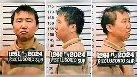 Government of Mexico A police mugshot showing three images of Zhang Zhidong, one facing forward, one facing to the left and one facing to the right. He has short dark hair and is wearing a beige polo shirt. There are lines on the wall behind him indicating height. Zhang is about 175cm tall.