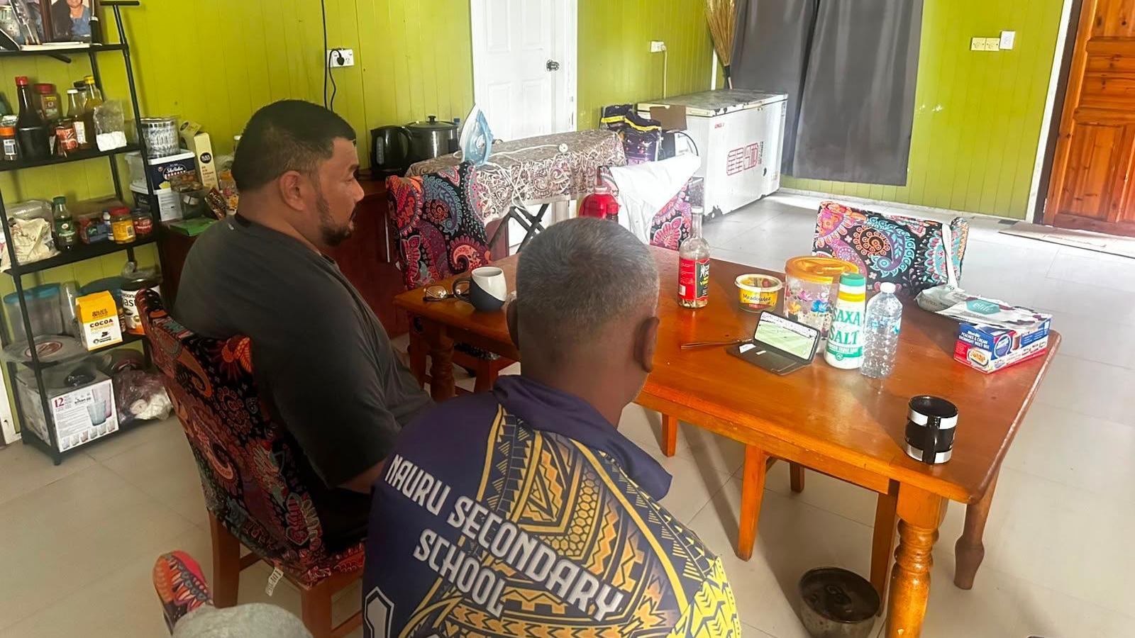 Two people watching the World Cup final on their phone in Nauru