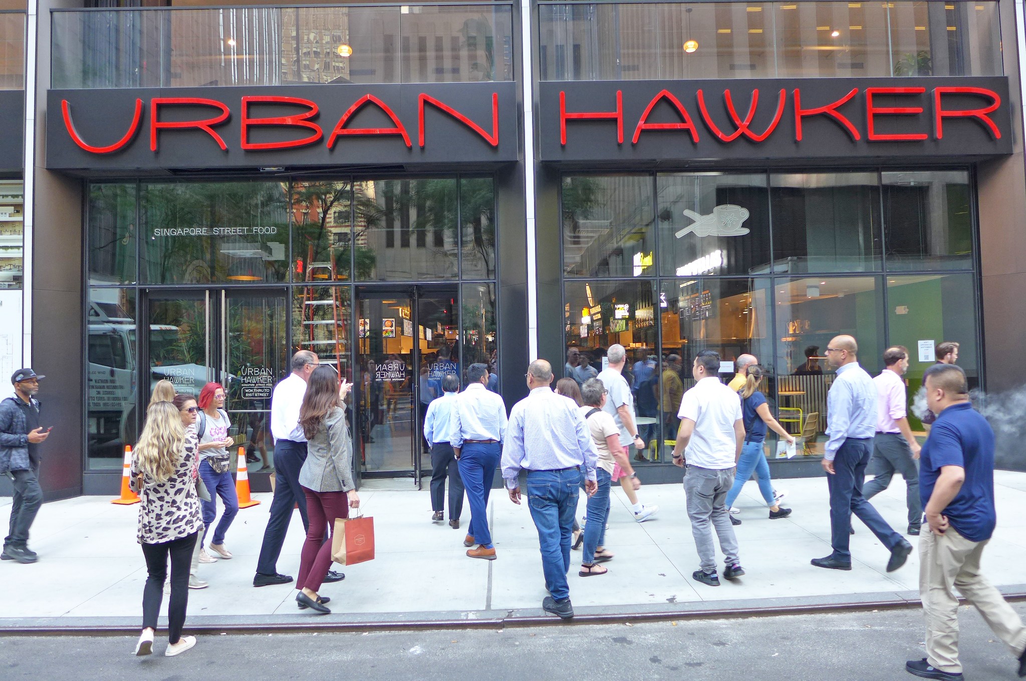 People on the sidewalk going toward the front door.