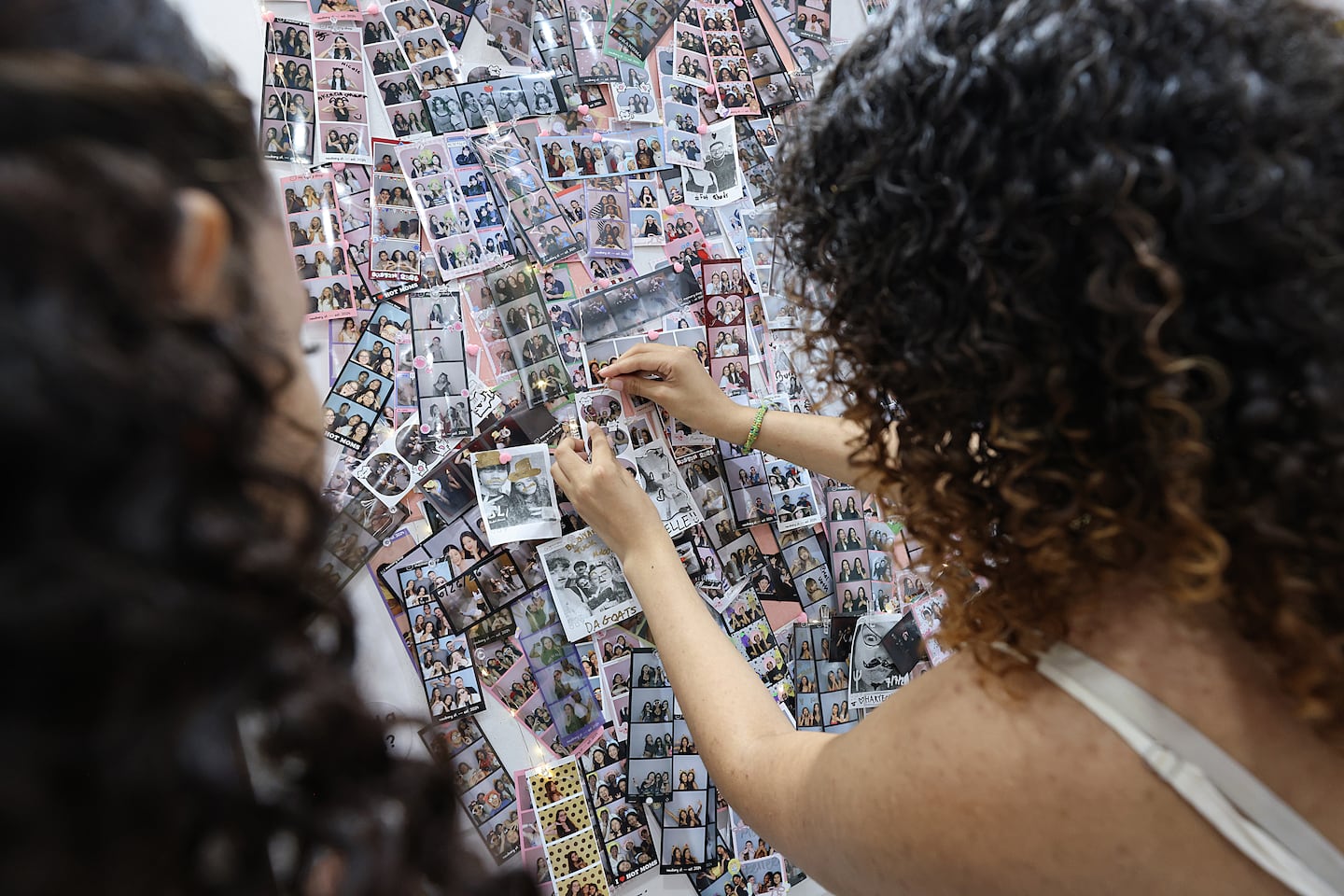 Women pinned photos inside of Memory Shop.