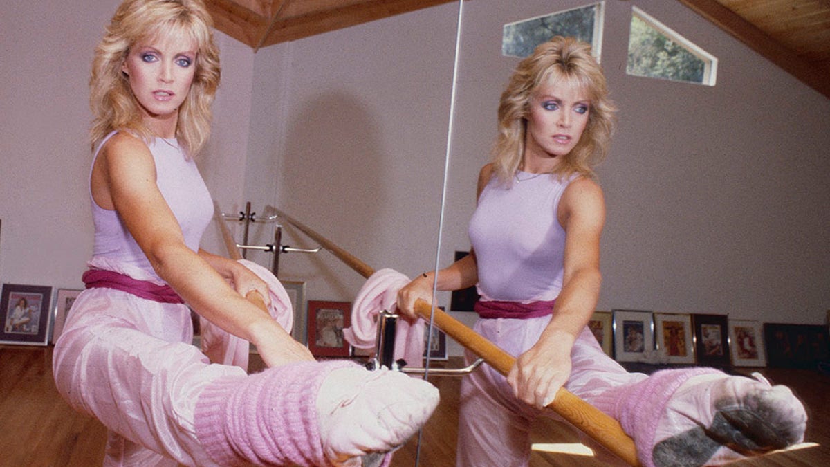 Portrait of American actress Donna Mills as she performs barre