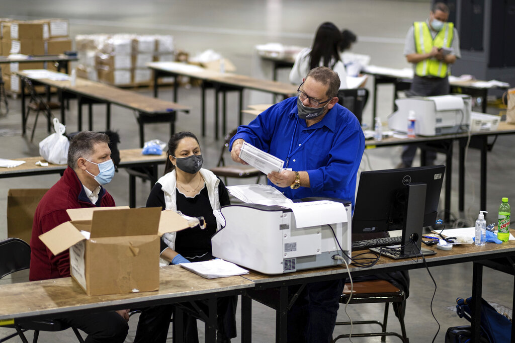 Workers scan ballots as the Fulton County presidential recount gets under way Wednesday morning, Nov. 25, 2020 at the Georgia World Congress Center in Atlanta.