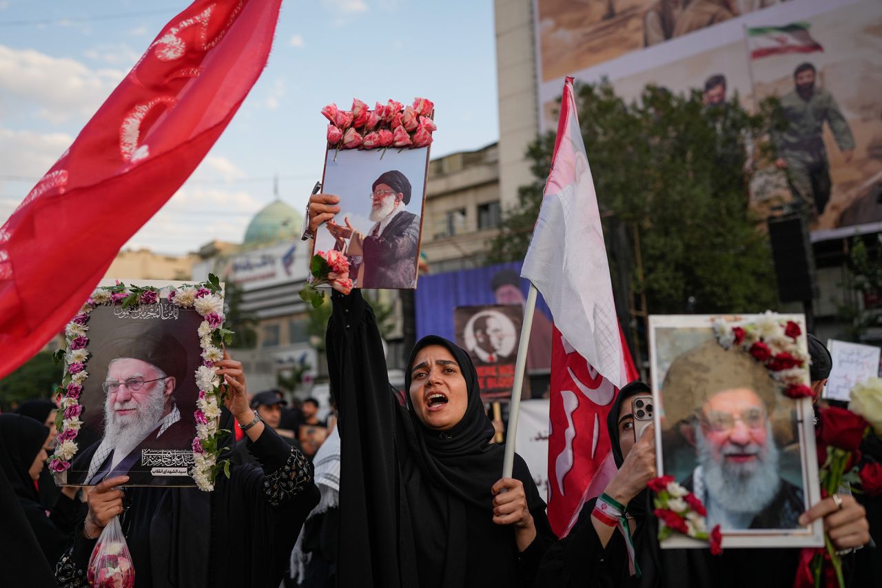 Mourners chant while holding flower-framed portraits of the slain Iranian Supreme Leader Ayatollah Ali Khamenei.