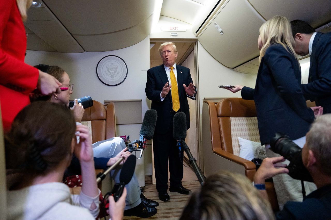 President Donald Trump speaks with reporters in flight on Air Force One after landing at US Air Force Base at RAF Mildenhall, in Suffolk, Eastern England, on Wednesday, July 8.