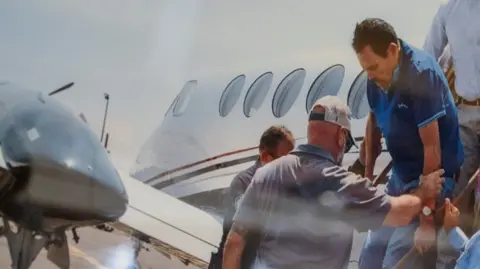 Reuters Zambada, in a blue golf shirt, is helped off a small plane while being taken into custody in July 2024