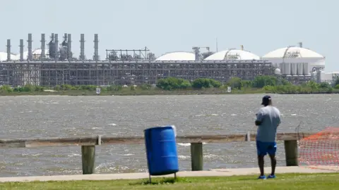 AFP via Getty Images A man stares across the bay from the vast Sabine Pass LNG export terminal, the world's largest