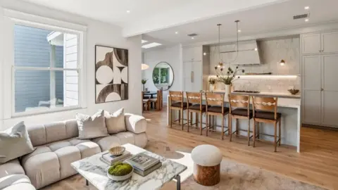Open Homes Photography The lounge and dining area of the apartment in San Francisco, with a sofa area and dining tables