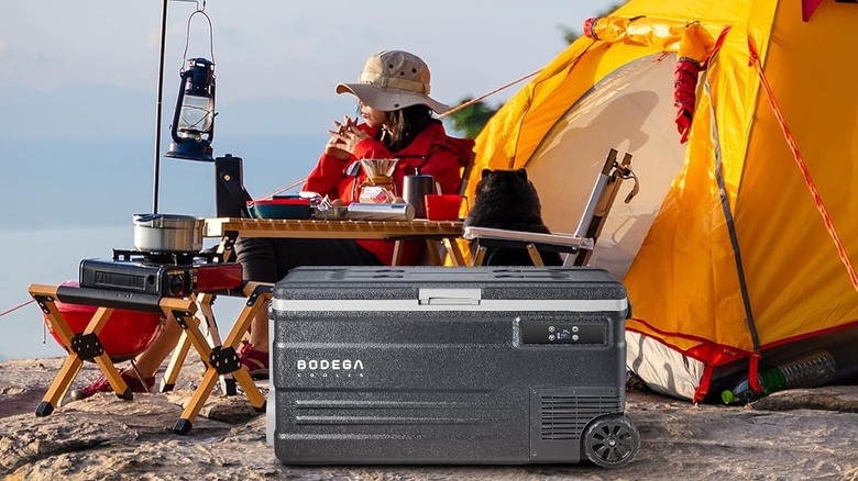 Bodega Cooler at a campsite alongside a tent, lantern, and portable stovetop