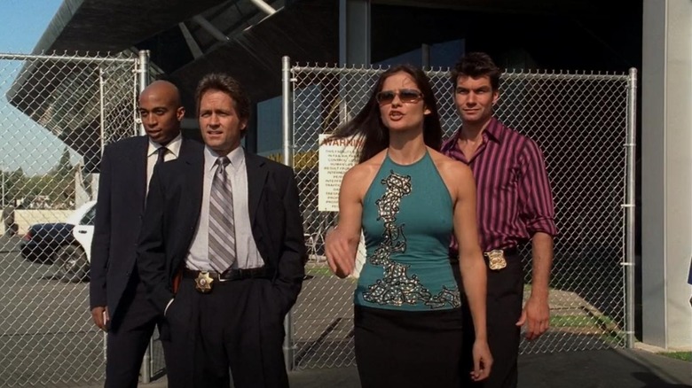 Mike Cannon (James Lesure), Luis Perez (Guy Ecker), Jordan Cavanaugh (Jill Hennessy), and Woody Hoyt (Jerry O'Connell) walk through a gate together in Las Vegas
