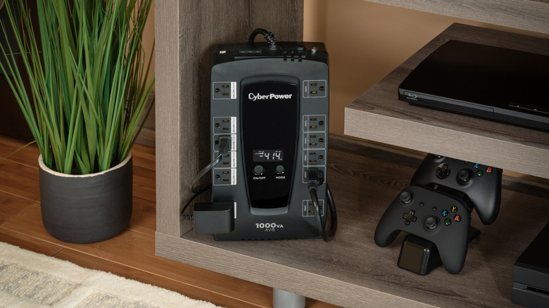 The CyberPower LE1000DG UPS placed in a TV unit, next to a DVD player and two controllers