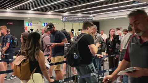 BBC People move through the queue for the Entry Exit System process at Fuimicino Airport in Rome, Italy.