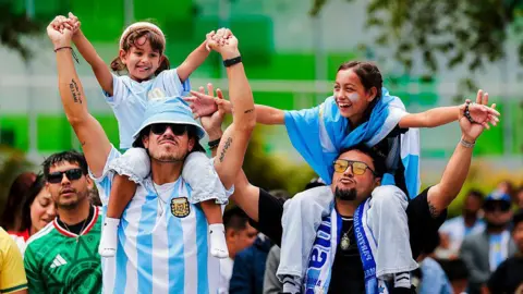 Getty Images Two Argentina fans carry two girls on their shoulders in San Francisco