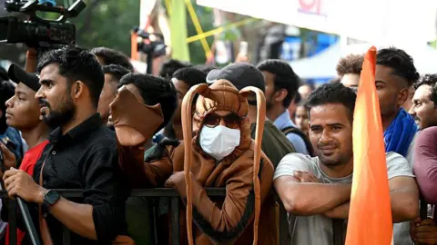 Getty Images A group of people, some looking at the camera, at the protest site in Jantar Mantar. One person in the centre is wearing a brown cockroach costume with long, drooping ears.
