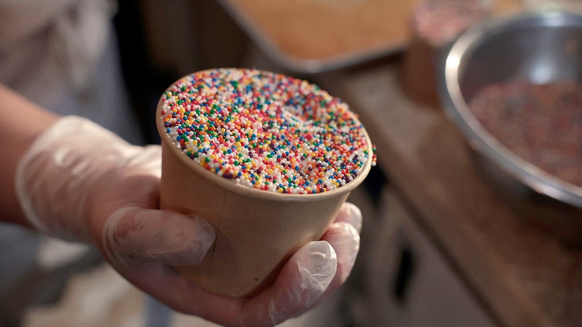 A person holds a dot cake.