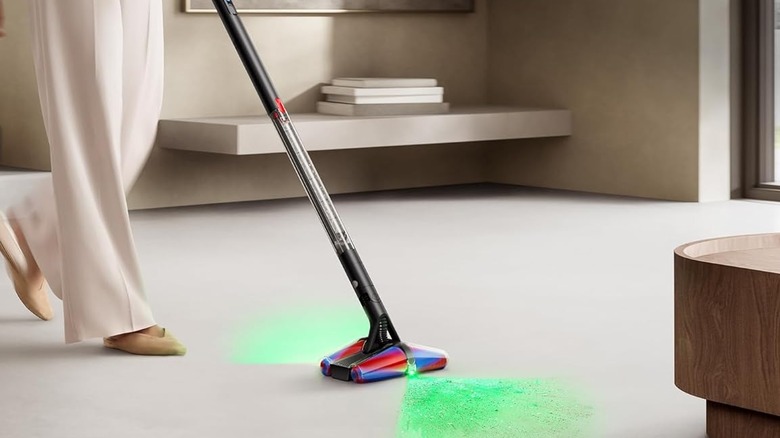 A person using the Dyson PencilVac Fluffycones hard floor vacuum.