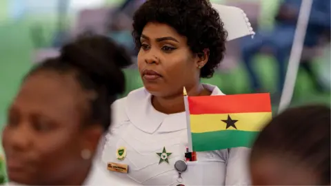 Getty Images A nurse with a Ghana flag looks on during independence day celebrations at the Jubilee House on 6 March 2025 in Accra.