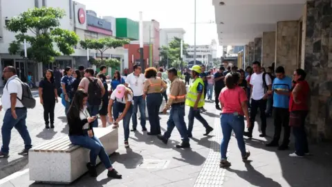 Reuters People pictured in a street in San Salvador, El Salvador's capital, following an evacuation