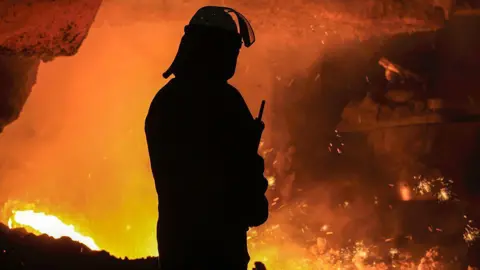 Getty Images A silhouette of a steel worker