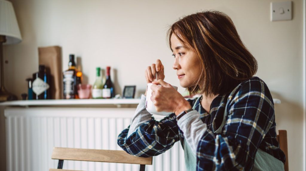 A woman gets ready to sip her cup of coffee after adding an artificial sweteener