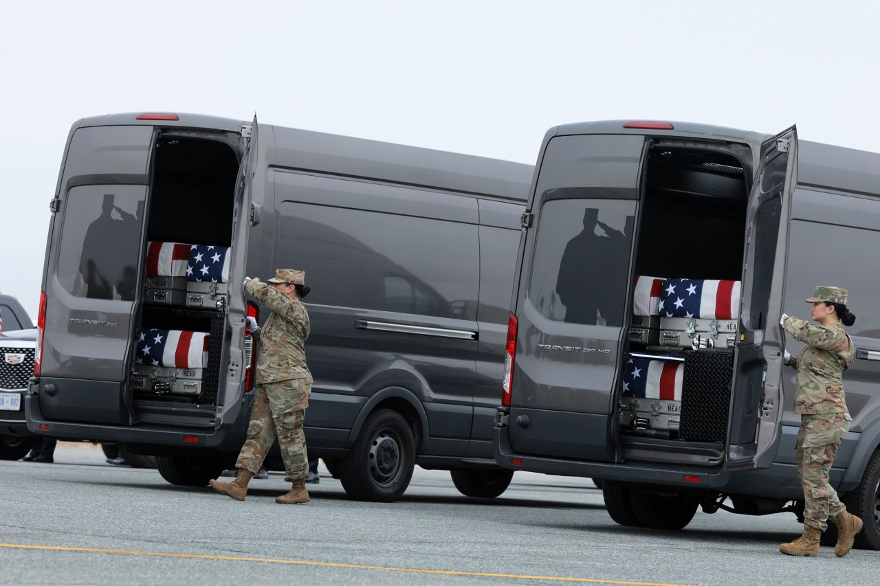 Members of a US Army carry team prepare to close the doors on a vehicle with flag-draped transfer cases, during a dignified transfer of six US troops killed by an Iranian drone strike in Kuwait, at Dover Air Force Base in Delaware, on March 7.