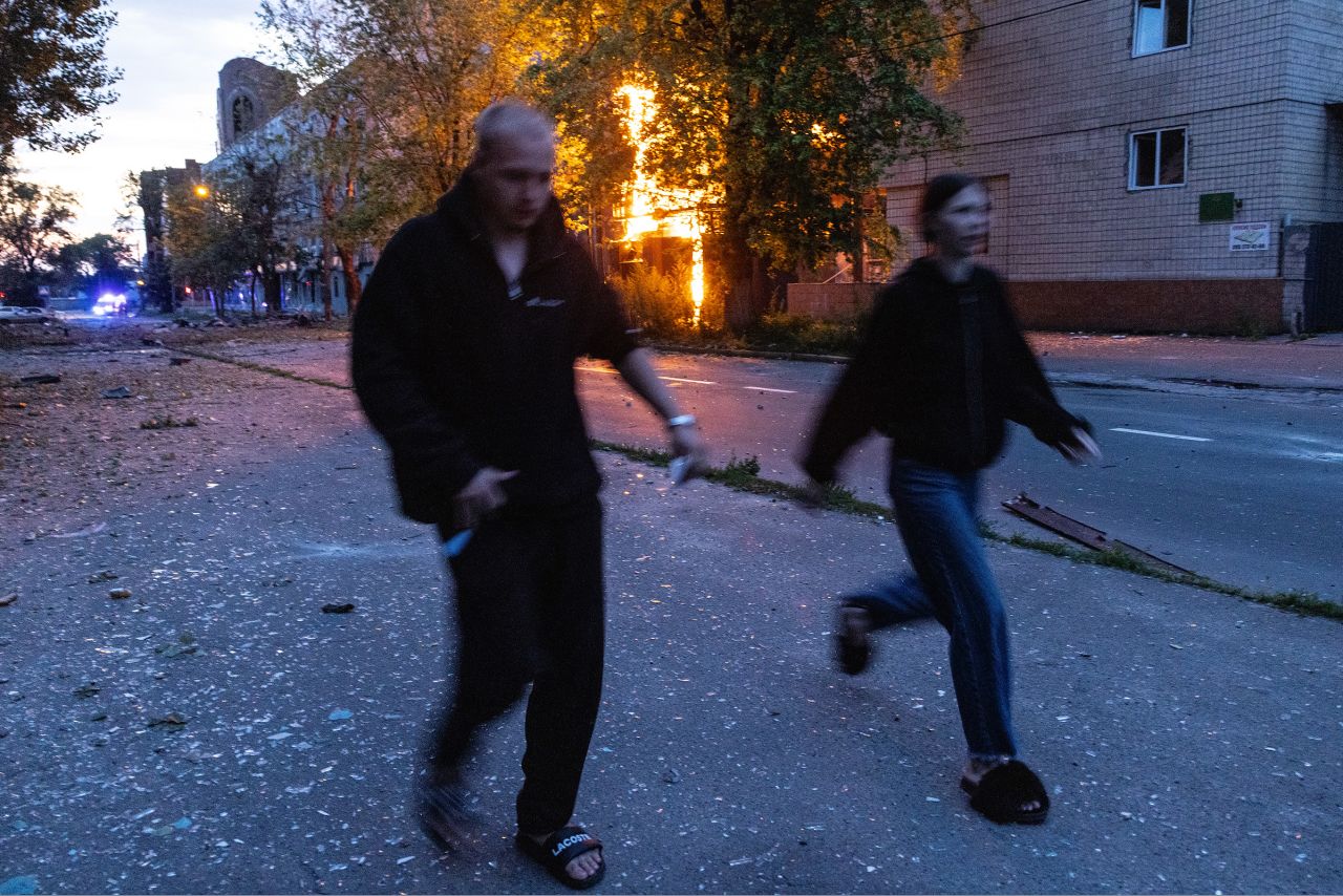 People run from a fire at the scene of a Russian missile and drone attack on Kyiv, Ukraine, on Monday.