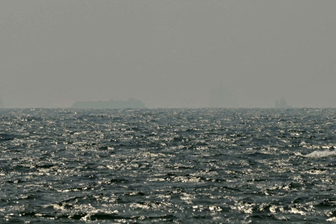 Ships are seen in the horizon as they sail off the coast of Ajman on July 10. Traffic through the Strait of Hormuz has fallen sharply since July 8, especially through the UN-backed Omani route, analysts said, after vessels were attacked earlier this week.